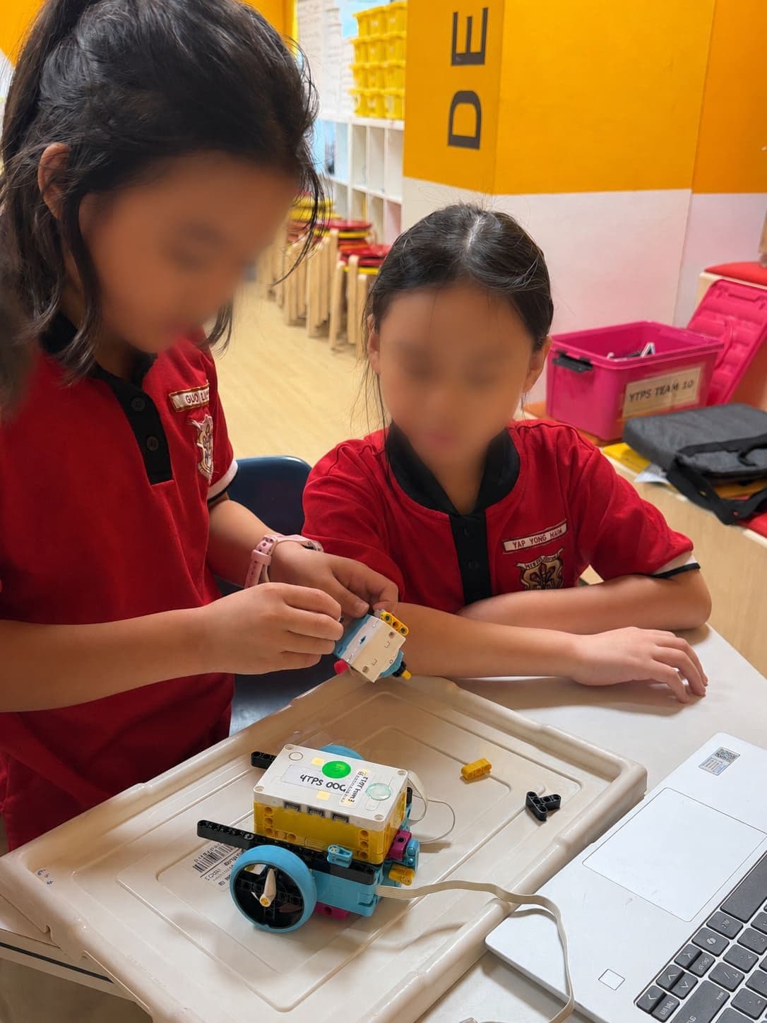 Two students working together on a SPIKE Prime robot during a school robotics CCA