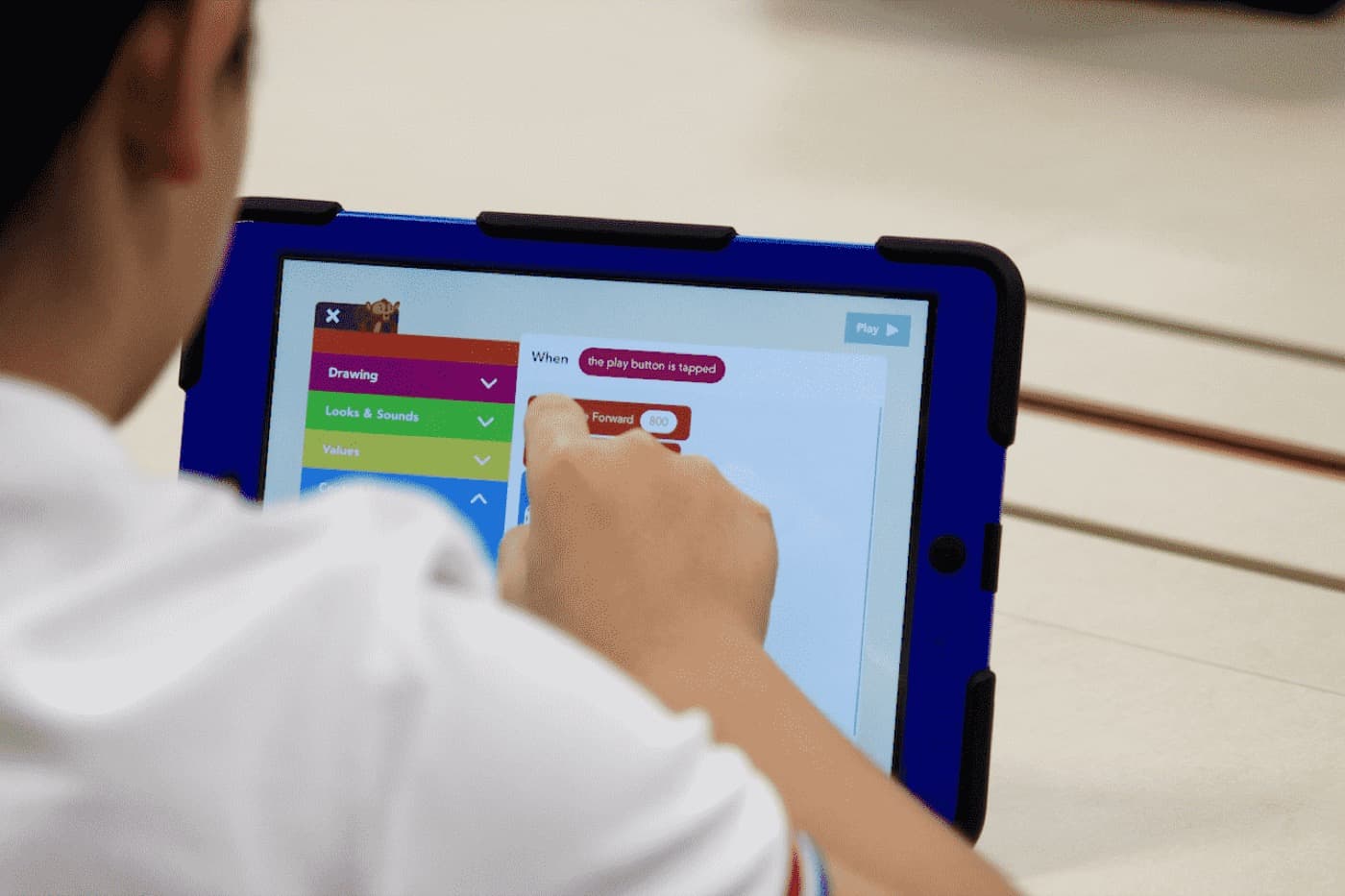 A student writing code on a tablet during a Code Gakko programme